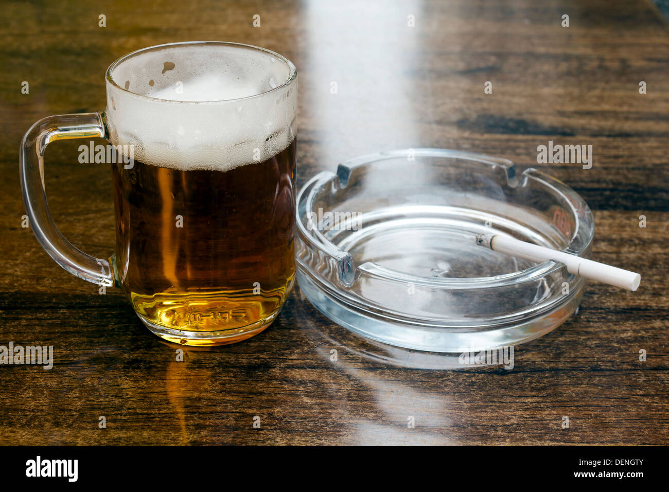 Glas Bier und einen Aschenbecher auf dem Tisch Stockfoto