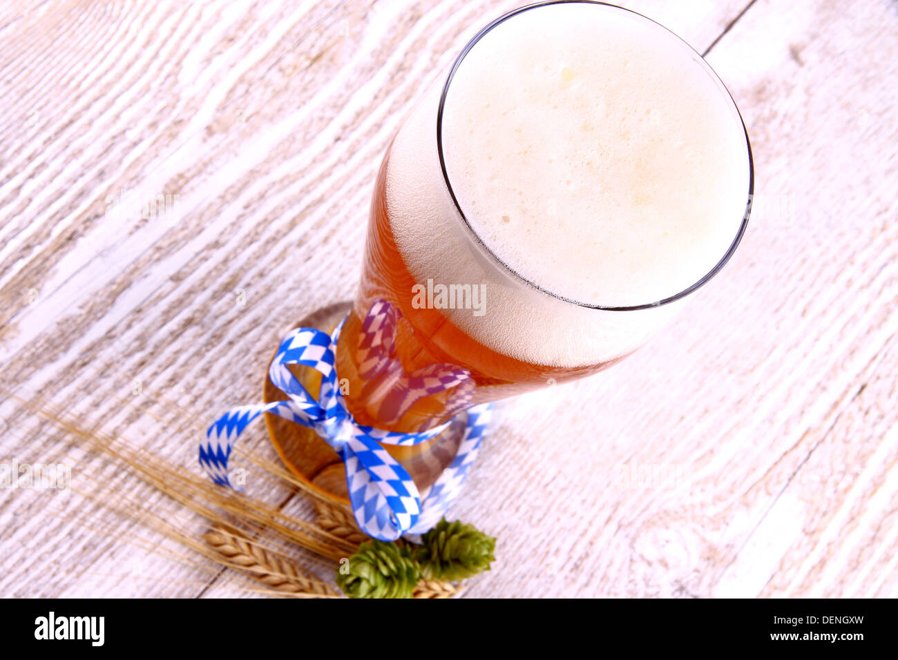 Weizenbier Glas mit blauem Band auf weißem Holz Hintergrund, Ansicht von oben Stockfoto