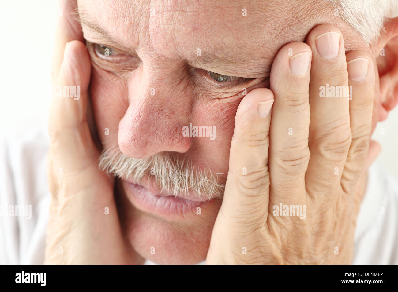 älterer Mann hält beide Hände bis zu seinem Gesicht Stockfoto