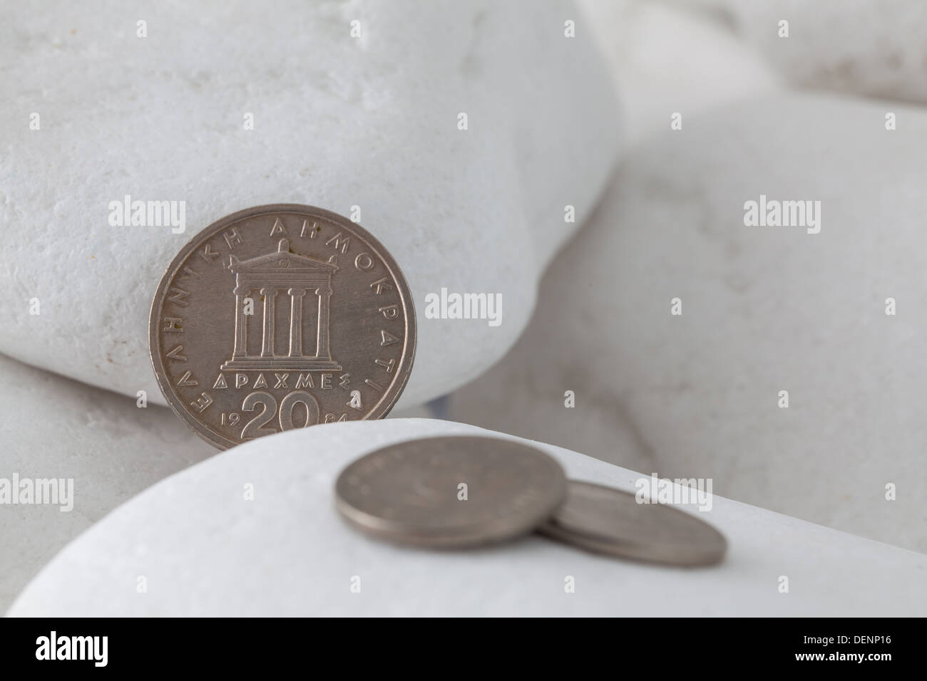 Griechische Münzen zwischen weißen Steinen Stockfoto
