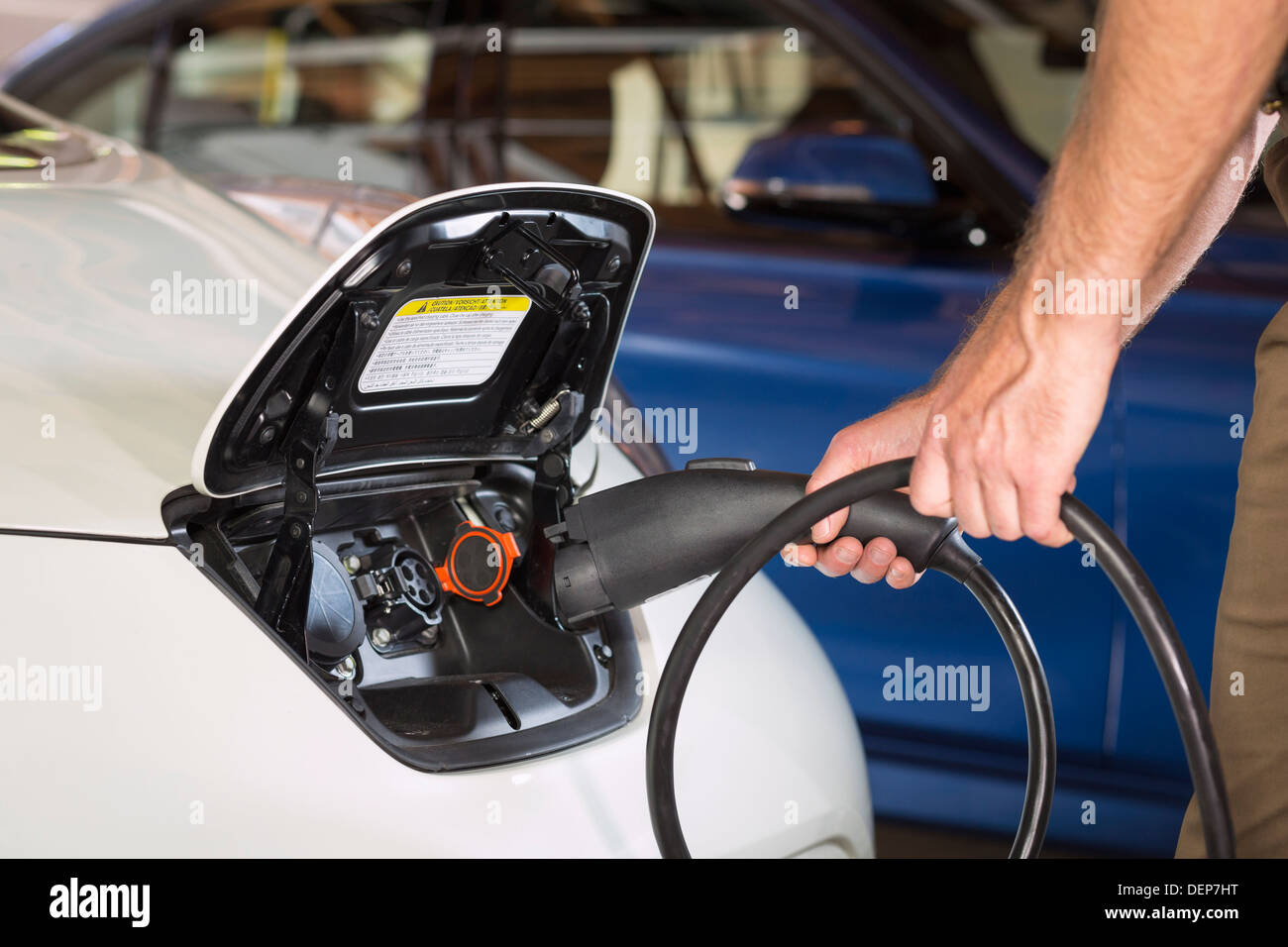 Nahaufnahme von kaukasischen Mann Elektroauto aufladen Stockfoto