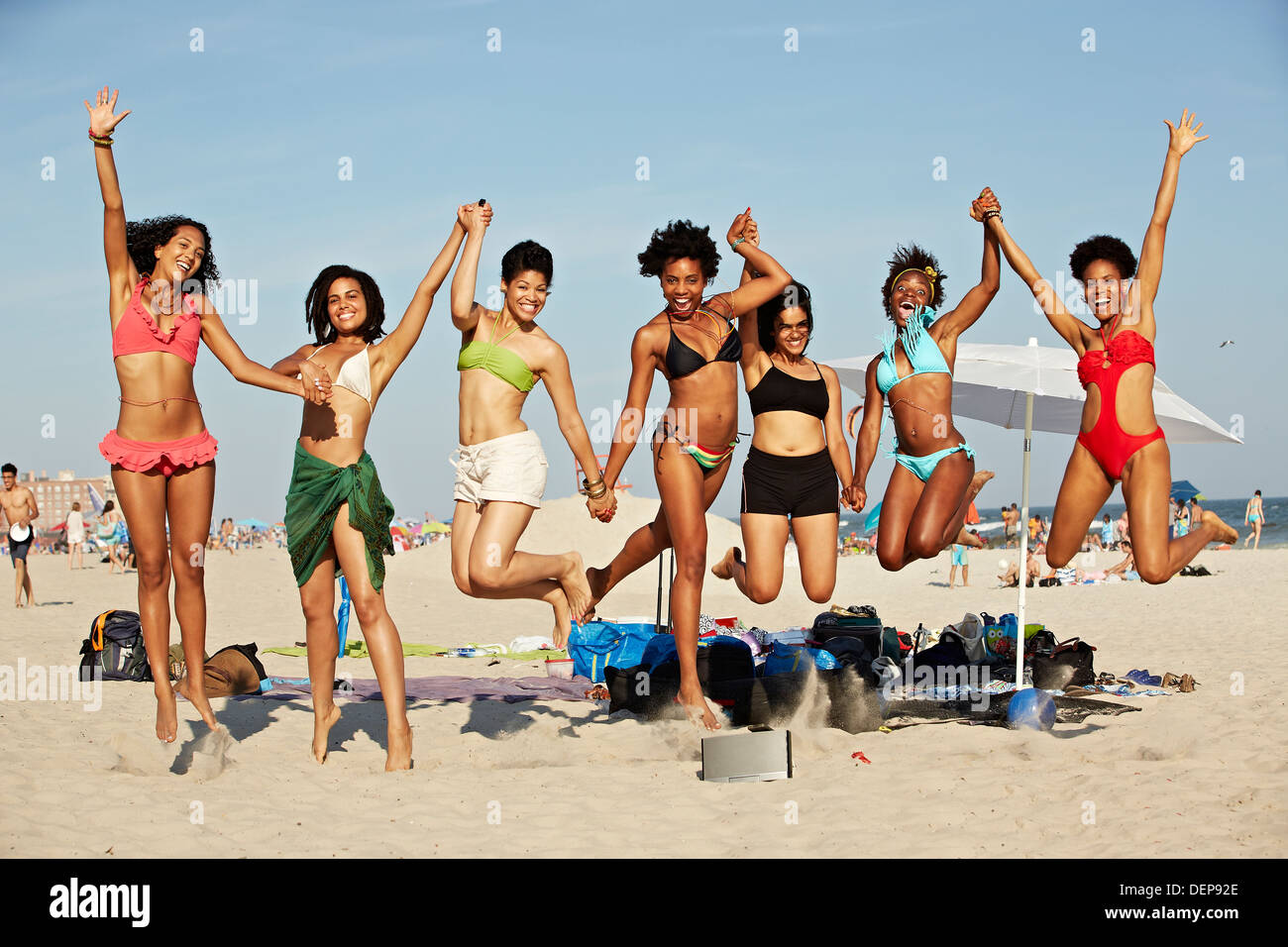 Frauen springen vor Freude am Strand Stockfoto