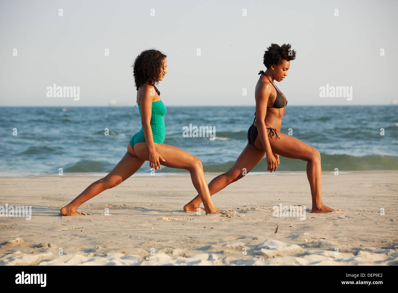 Frauen üben Yoga am Strand Stockfoto