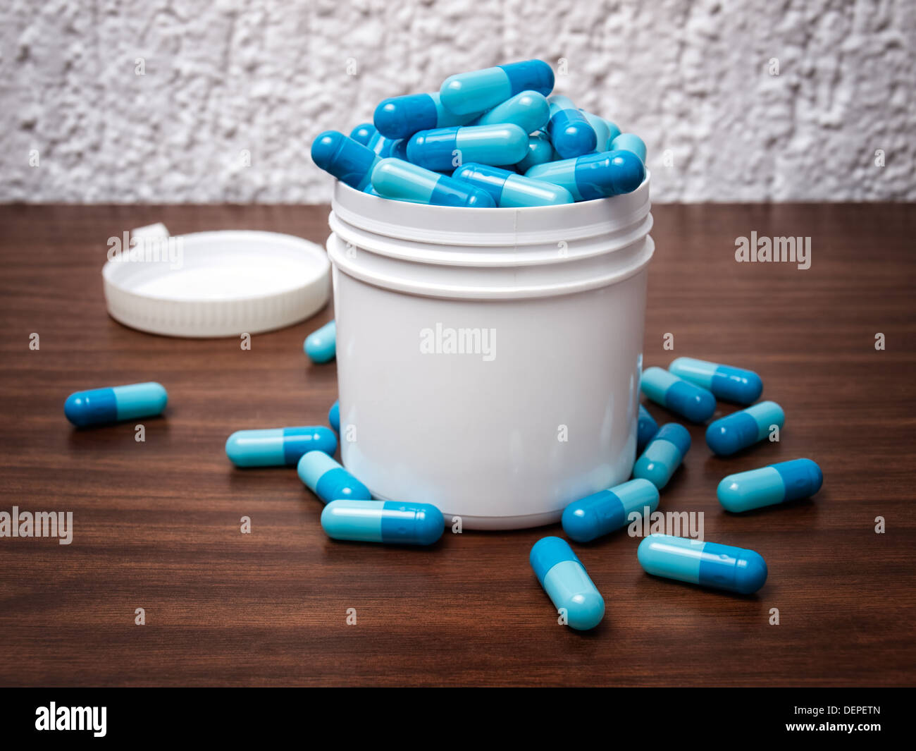 Kunststoff-Box mit blauen Pillen überfüllt. Stockfoto