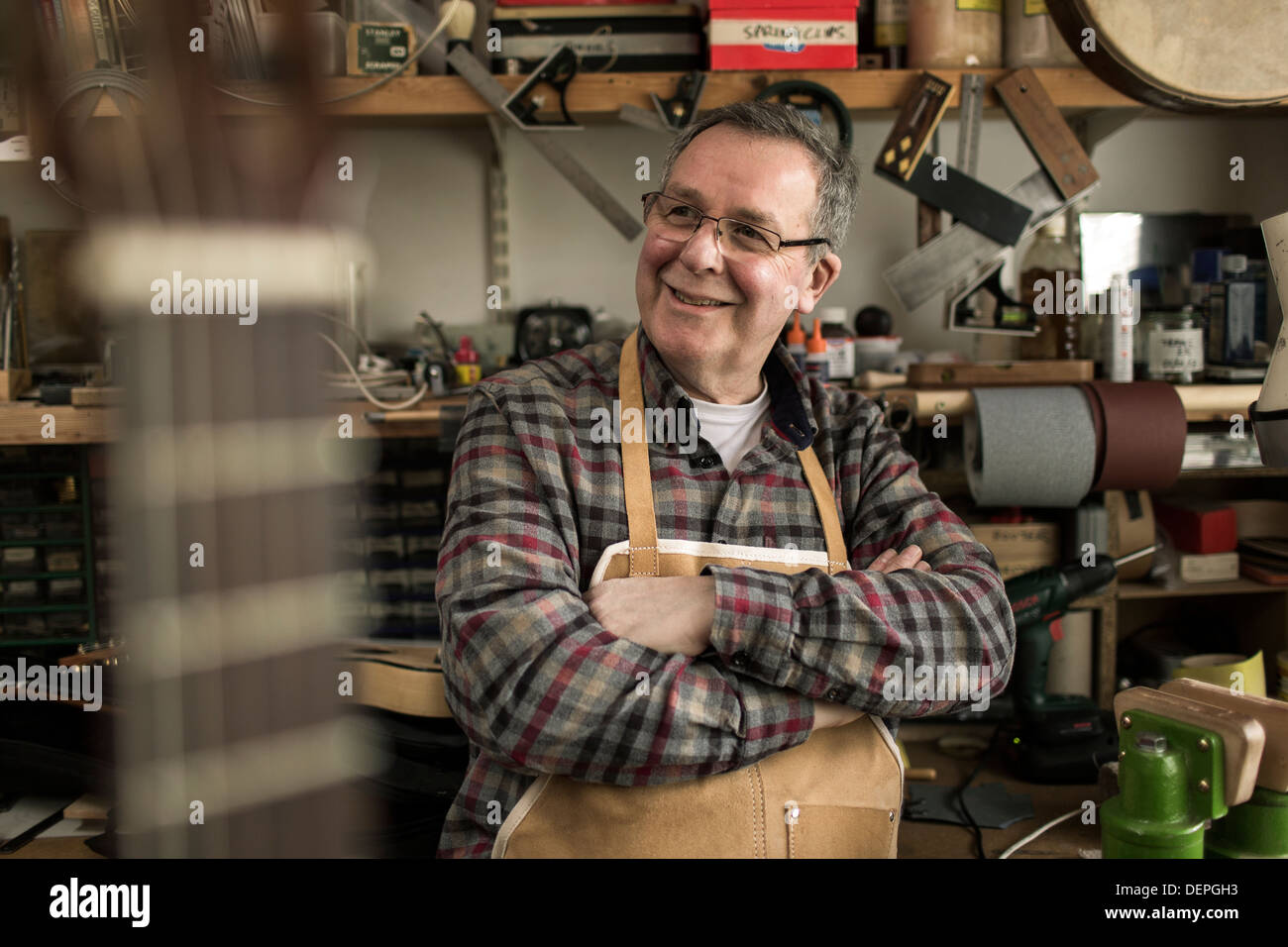 Gitarrenbauer stehend in Werkstatt, Lächeln Stockfoto