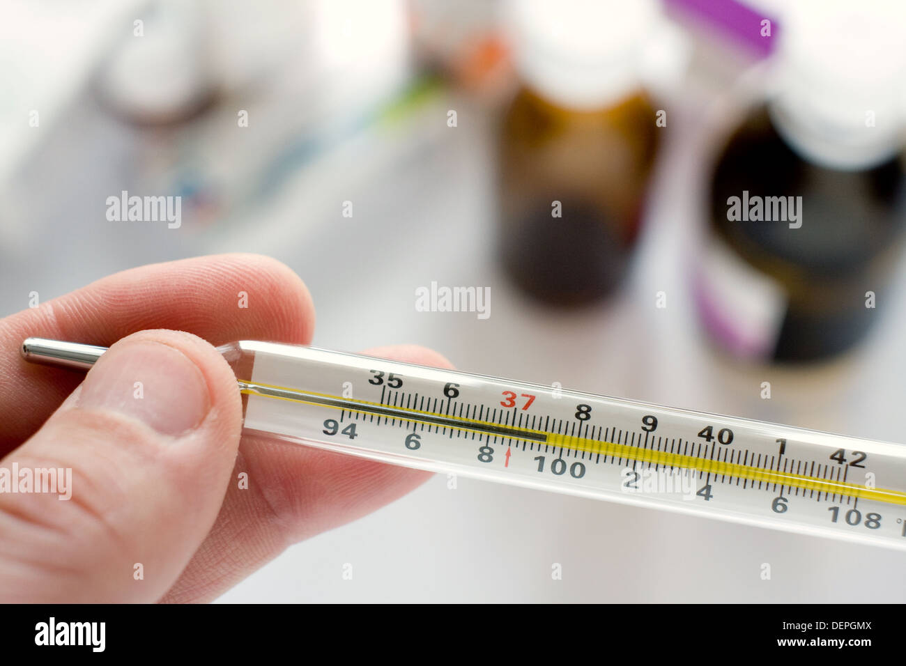 Des Arztes Hand mit Thermometer zeigt eine hohe Temperatur Stockfoto