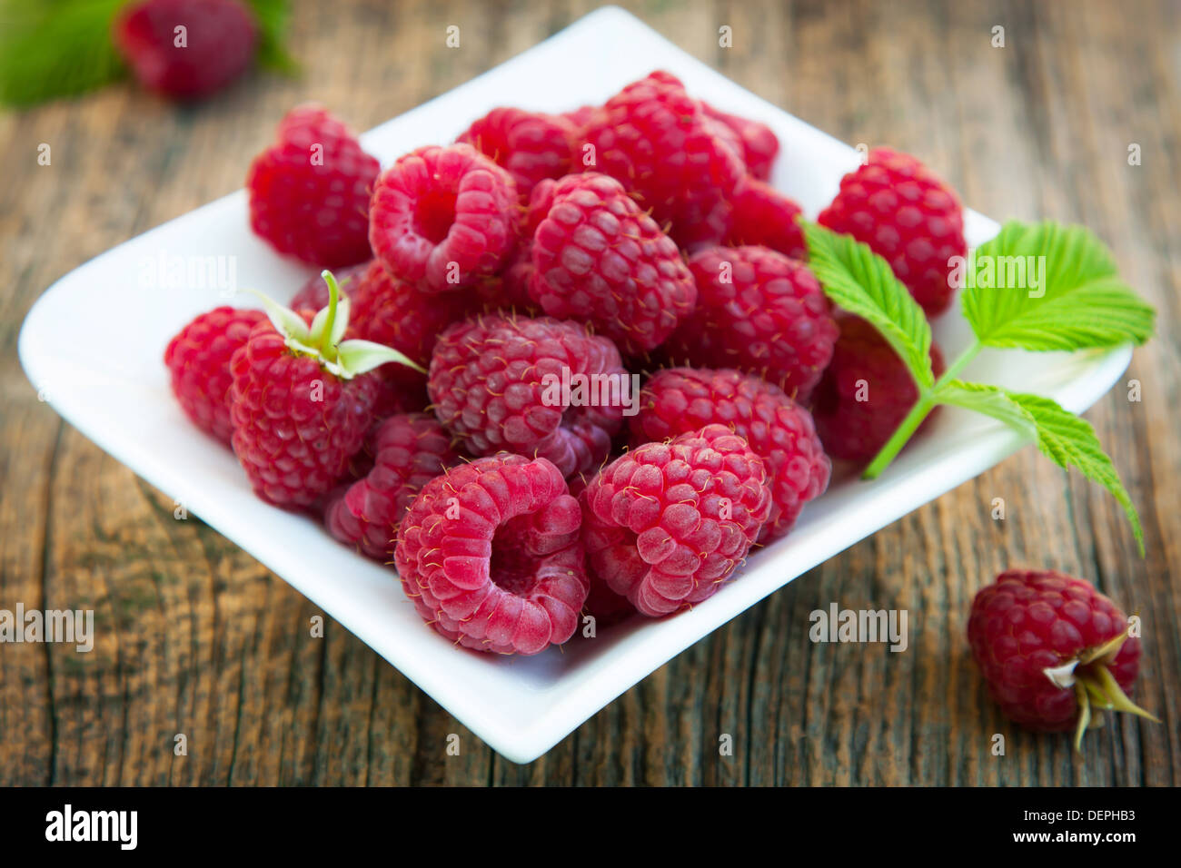 Frische und reife Himbeeren auf kleine Teller Stockfoto