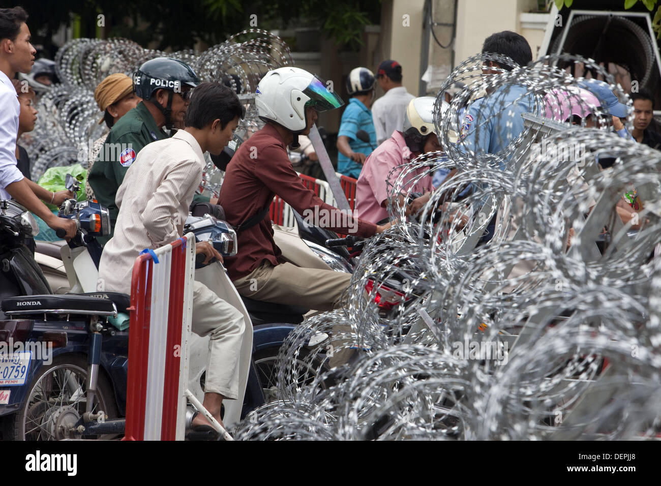 Phnom Penh, Phnom Penh, Kambodscha. 23. September 2013. Autofahrer und Fußgänger zu ertragen Stillstand wie Verkehr führt zu Freedom Park und das Gebäude der Nationalversammlung Straßen mit Stacheldraht und Eisen Fechten, protestieren zu verhindern versucht blockiert wurden. Heute früh wurde nach den Wahlen Öffnung des Parlaments, die von der Opposition Partei Kambodschas nationalen Rettung boykottiert wurde. Oppositionsführer Sam Rainsy forderte die Einberufung des Parlaments ohne die Opposition eines Verstoß gegen die Verfassung. Bildnachweis: Gary Dwight Miller/ZUMAPRESS.com/Alamy Live-Nachrichten Stockfoto