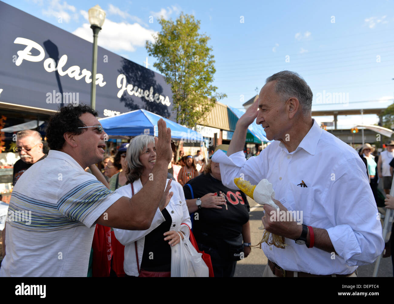 Bellmore, New York, USA 22. September 2013. US-Senator CHARLES "CHUCK" SCHUMER (Demokrat), läuft für eine Wiederwahl im November, und ein Mann schlagen "high Five", während bei der Senator Kampagne Besuch am 27. jährlichen Bellmore Festival miteinander zu reden, mit Familienspaß mit Ausstellungen und Attraktionen in einem 25 Quadratmeter sperren Bereich, mit mehr als 120.000 Menschen voraussichtlich über das Wochenende teilnehmen. Bildnachweis: Ann E Parry/Alamy Live-Nachrichten Stockfoto