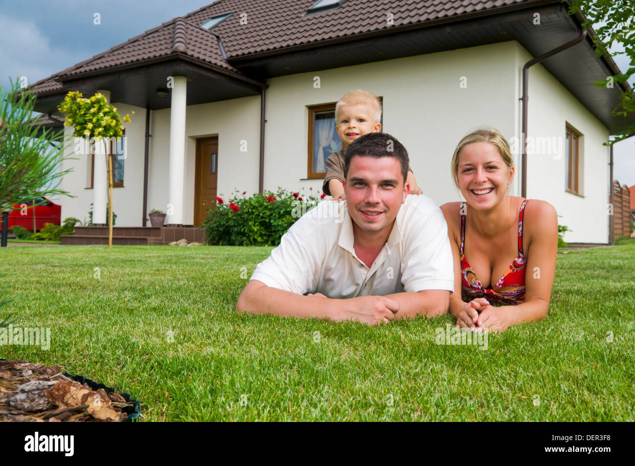 Eine glückliche Familie vor ihrem Haus im Garten Stockfoto