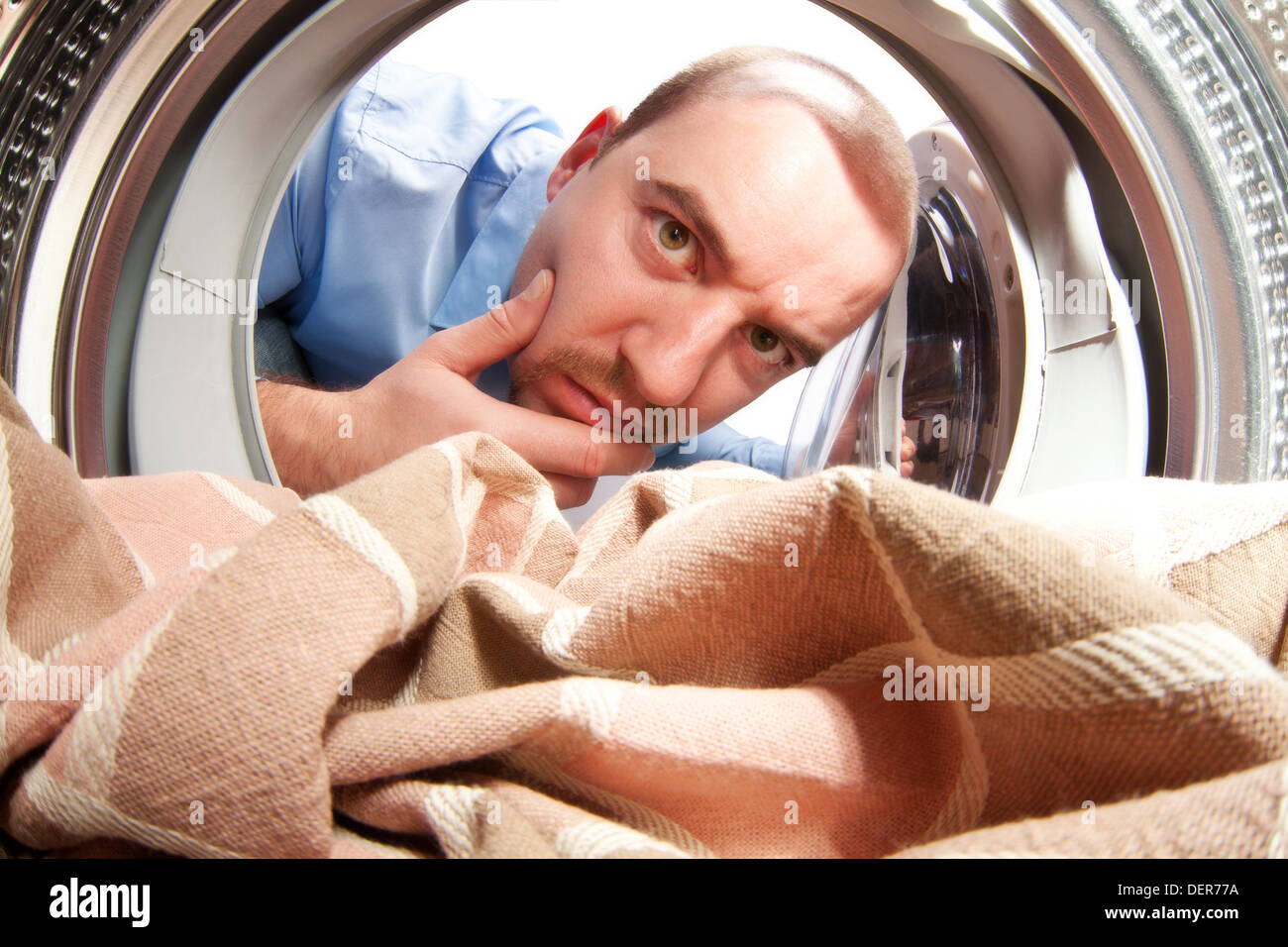 Porträt des Mannes von innerhalb der Waschmaschine Stockfoto