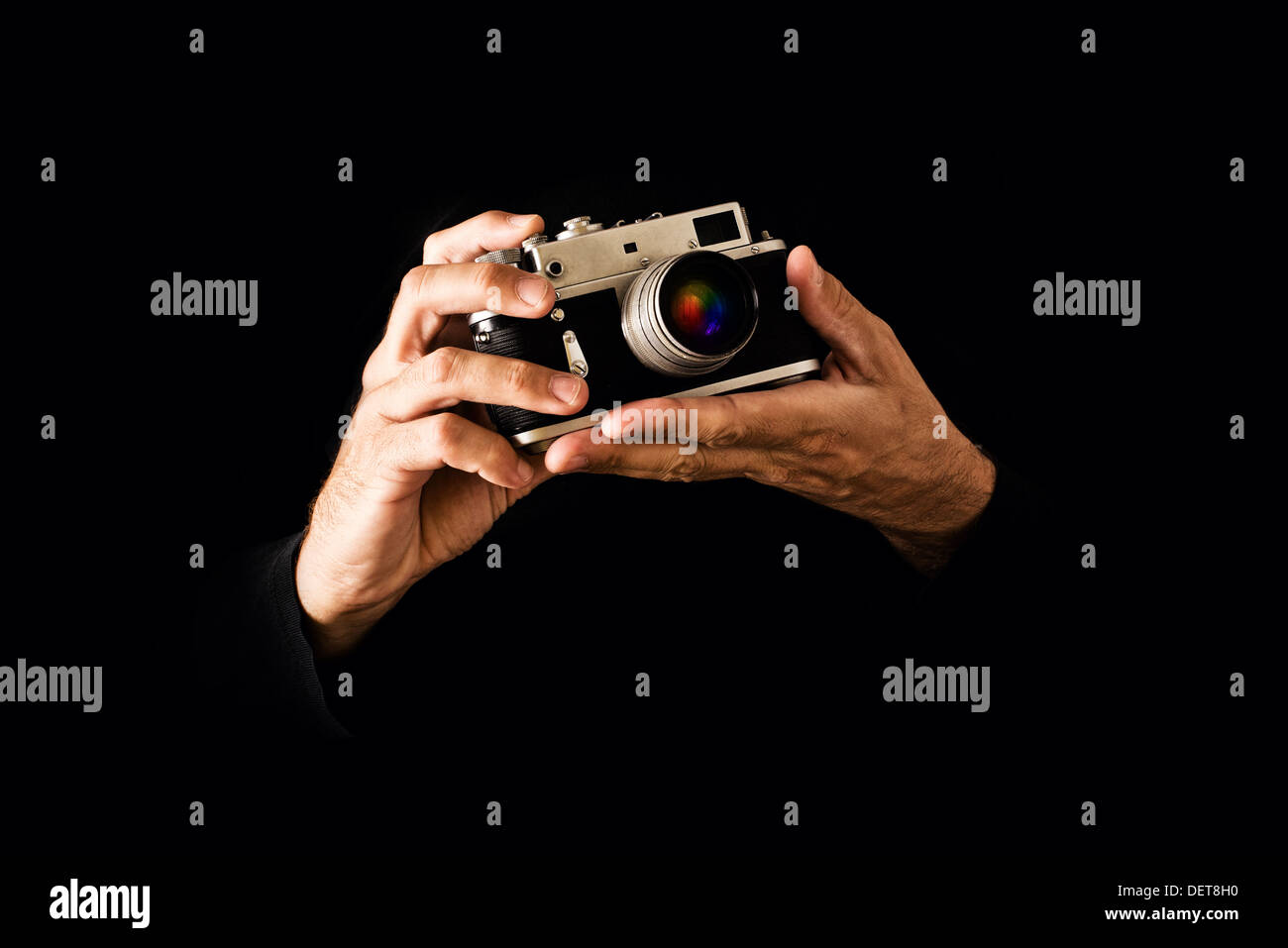 Mann hält Vintage Fotografie Kamera auf schwarzem Hintergrund. Stockfoto
