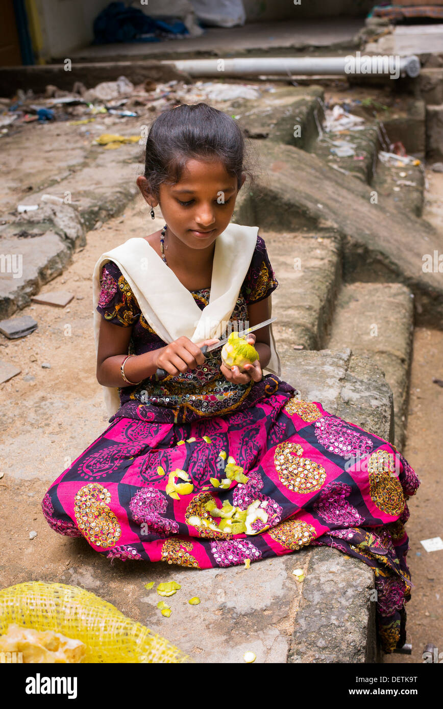 Inderin, die Orangen schälen, mit einem Messer an einer Dorfstraße. Puttaparthi Andhra Pradesh, Indien Stockfoto