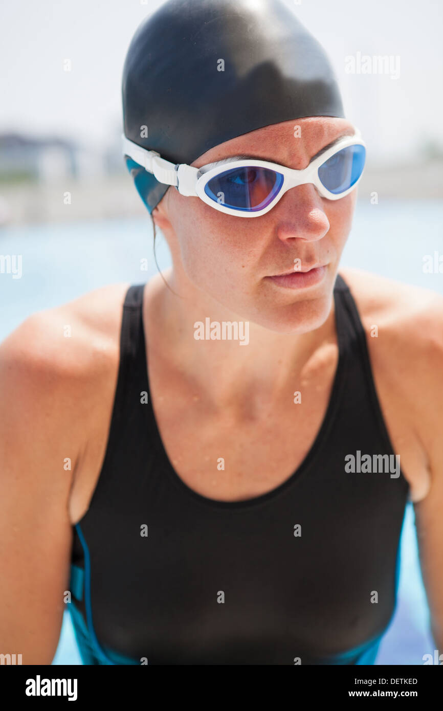 Porträt von weiblichen Schwimmer mit Brille und schwarzen Badeanzug und Kappe am Außenpool Stockfoto