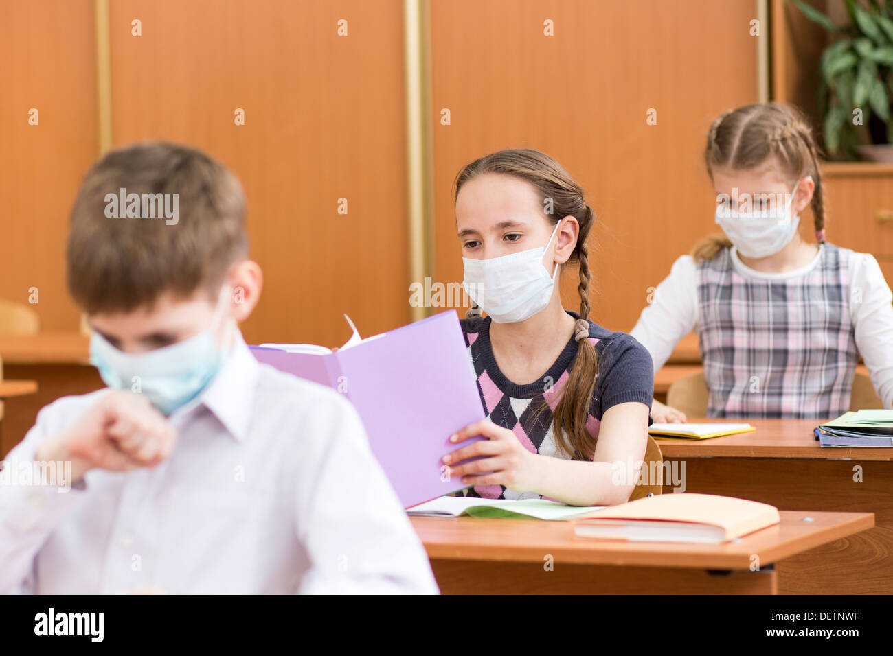 Schülerinnen und Schüler mit Maske Schutz gegen Grippe-Virus bei Lektion Stockfoto