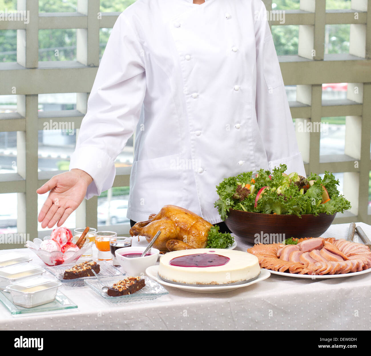 Köchin zeigt eine Menge von gekochten Speisen und Backwaren Stockfoto