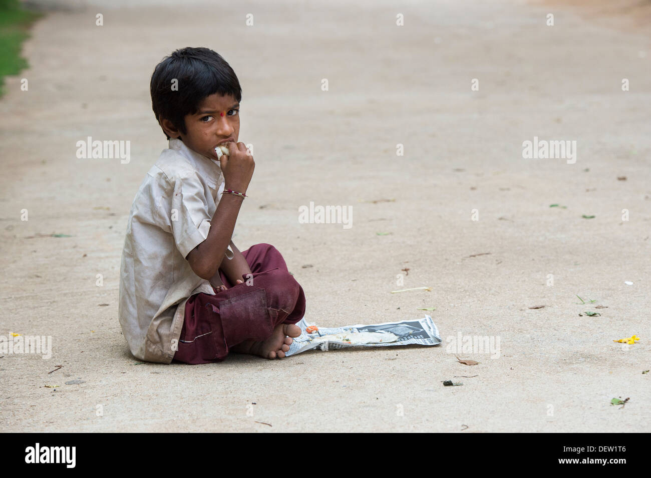 Niedrigere Kaste Indianerjunge Dosa zum Frühstück auf einer indischen Straße zu essen. Andhra Pradesh, Indien. Textfreiraum Stockfoto