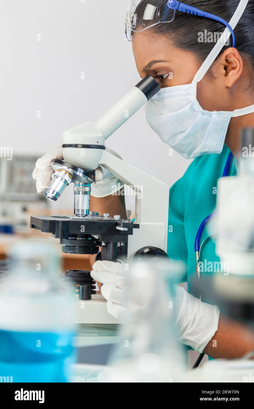 Eine asiatische Frauen Arzt oder wissenschaftlicher Mitarbeiter mit ihrem Mikroskop im Labor. Stockfoto