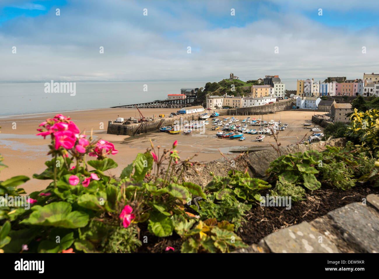 Nordstrand Tenby Pembrokeshire. Hafen bei Ebbe mit festgemachten Boote Andregency Reihenhaus Häuser in Pastellfarben. Stockfoto