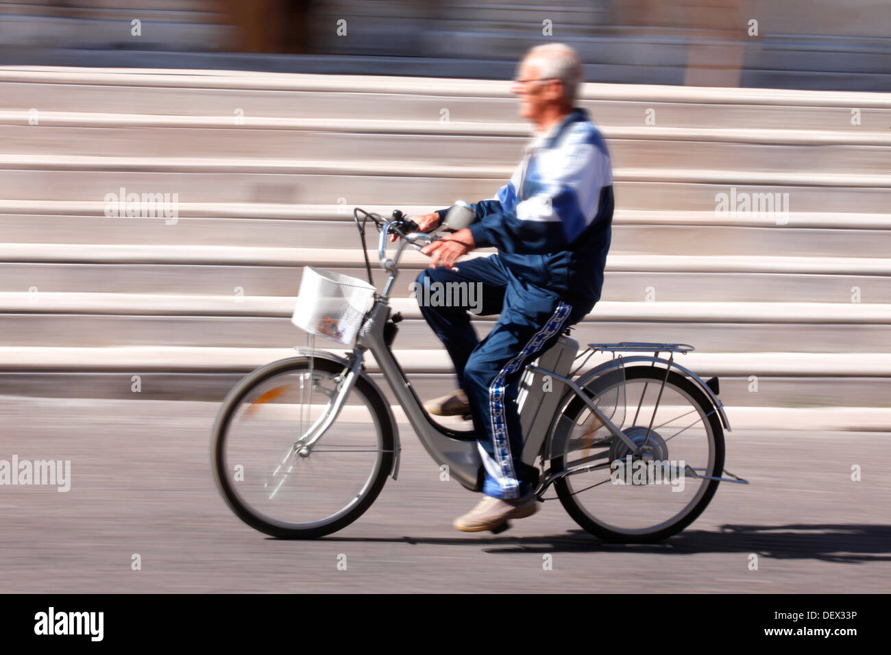 Ein älterer Mann Reiten ein Elektrofahrrad in Italien. Stockfoto