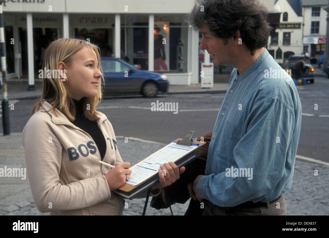 Teenager-Mädchen mit Zwischenablage interviewte Mann auf der Straße Stockfoto