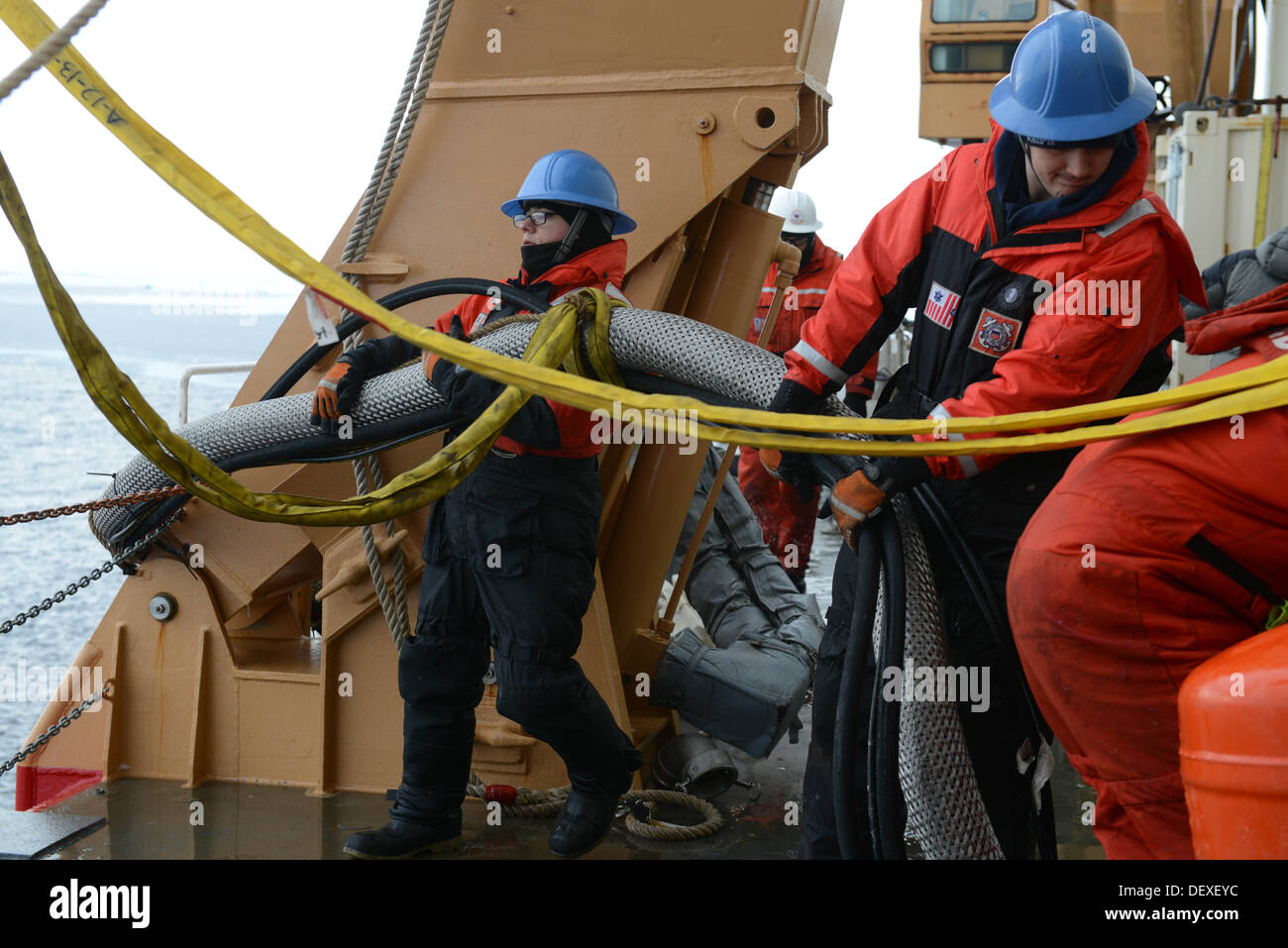 Seaman Aaron Lopez und Seaman Alex Cason, Mitglieder des Fachbereichs Coast Guard Cutter Healy Deck helfen den Schlauch für eine Öl-skimming behandeln? System während eines simulierten Öl verschütten Antwort Übung in den arktischen Ozean, 12. September 2013. Die Crew von Healy, einem Stockfoto