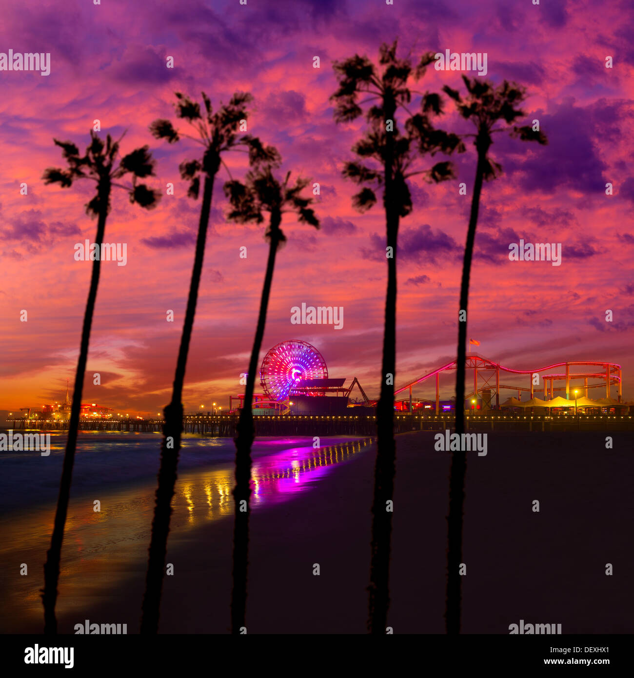 Santa Monica California Sunset Pier Ferrys Rad und Reflexion auf nassen Strandsand Stockfoto