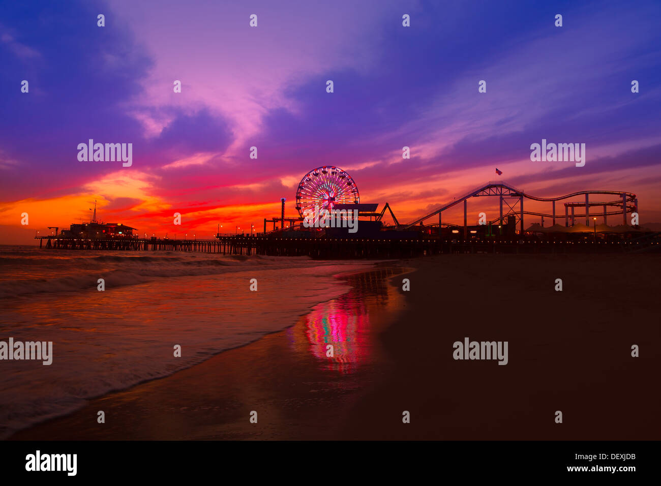 Santa Monica California Sunset Pier Ferrys Rad und Reflexion auf nassen Strandsand Stockfoto