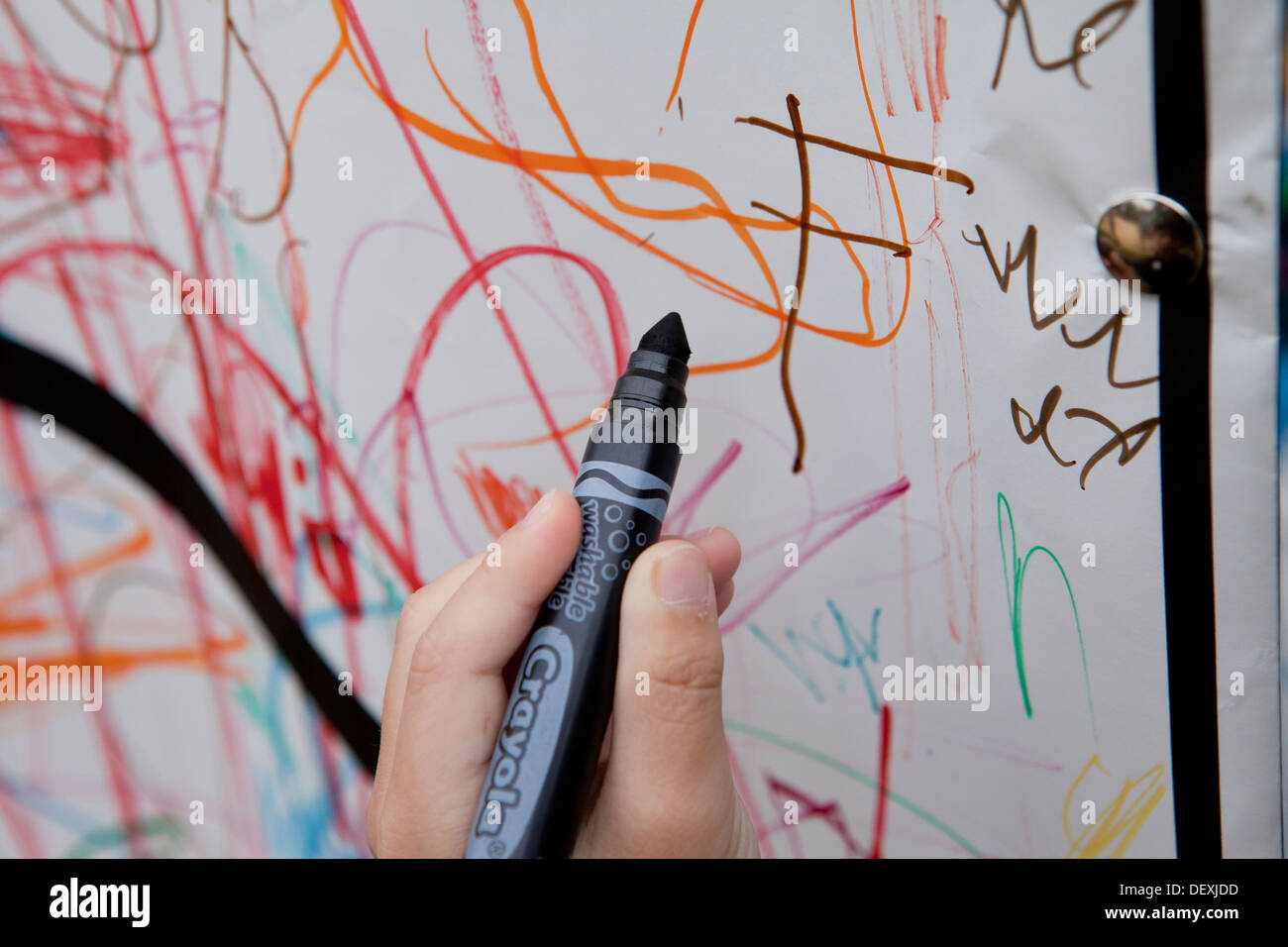 Kind mit Filzstift Marker an Wand zeichnen Stockfoto