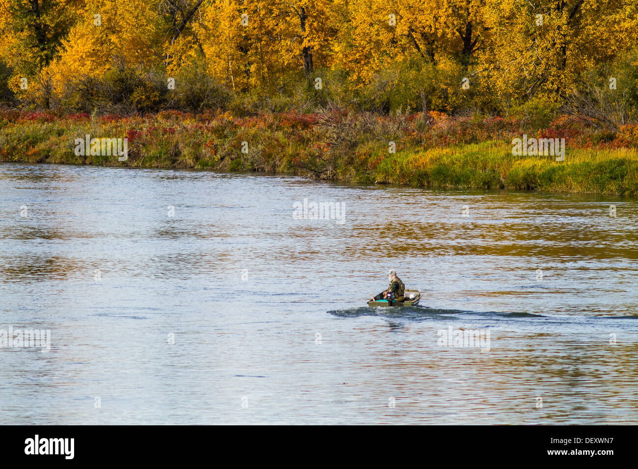 Malerische, bunte, schöne, schöne Herbst Einstellung der Fischer Umzug durch blaues Wasser mit Hintergrund der Herbstfarben Stockfoto