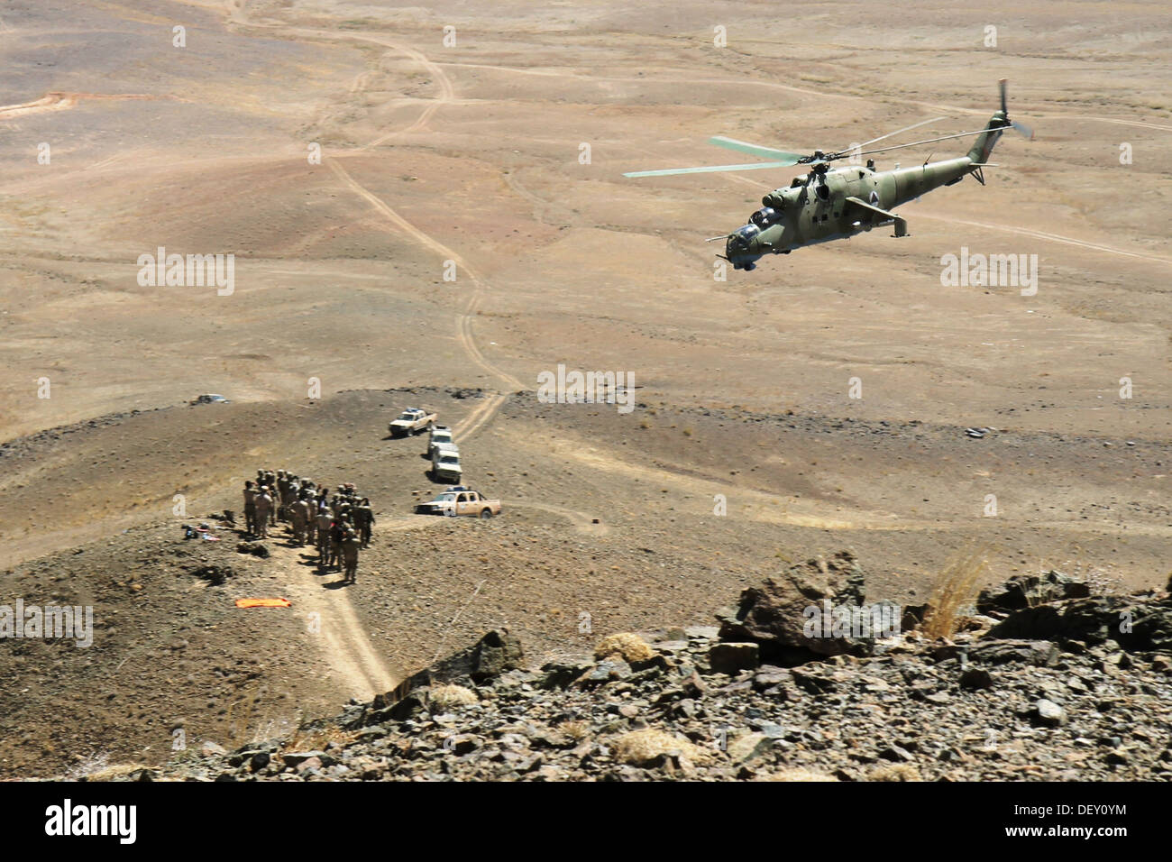 Ein afghanische Luftwaffe Mi-35 Hubschrauber fliegt über eine Gruppe von Soldaten der afghanischen Nationalarmee mit 4. Infanterie-Brigade, 203. Korps und US Air Force und US Army Berater, 18. September 2013, in der Provinz Logar, Afghanistan, während eine live-Feuer-Luft zu Boden in Stockfoto