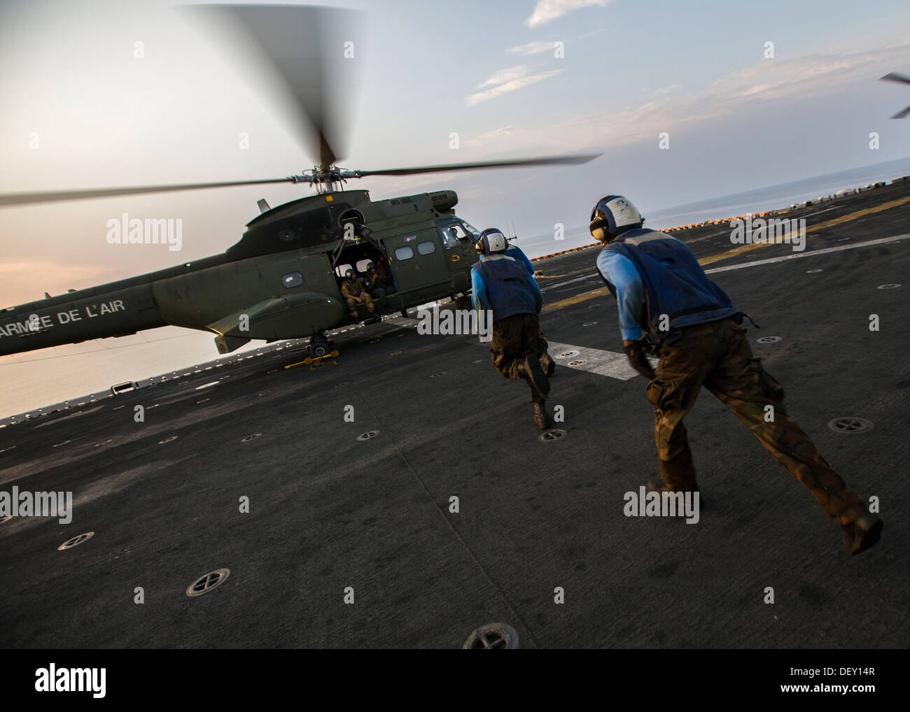 Matrosen laufen, um die Ketten aus einem französischen SA 330 Puma Hubschrauber auf dem Flugdeck der USS Kearsarge (LHD-3), 22. September 2013 zu entfernen. Die 26. MEU ist eine Marine Air-Ground Task Force für den US-5. und 6. Flotte Bereichen Verantwortung Ab vorwärts bereitgestellt Stockfoto