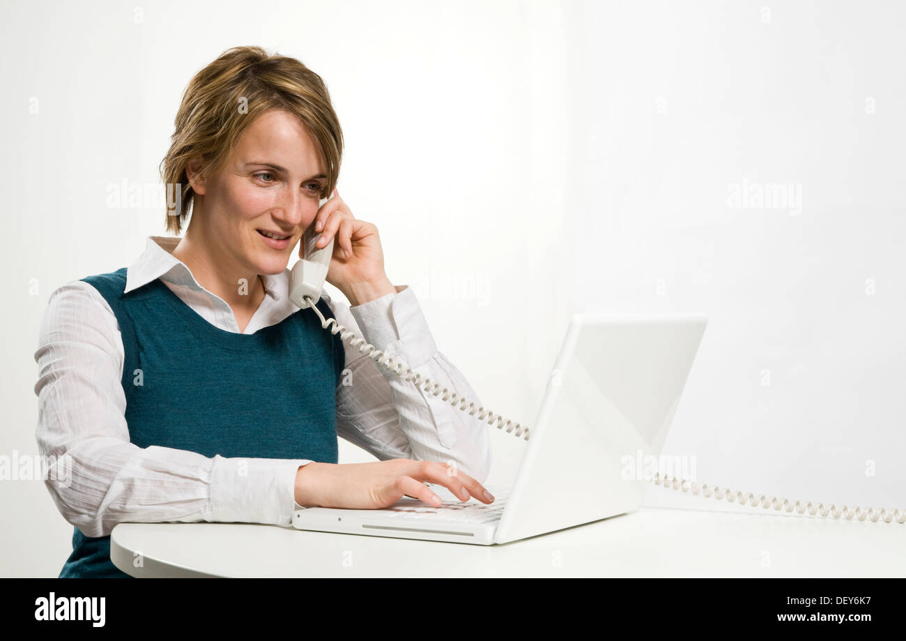 Junge Frau mit Telefon und computer Stockfoto