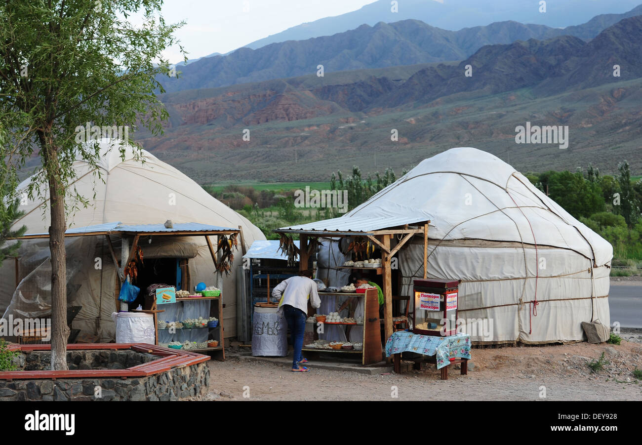 Eine Frau kauft Lebensmittel aus einer Jurte in Kirgisistan, 19. Juli 2013. Jurten haben als mobile Behausungen in Zentralasien seit Tausenden von Jahren verwendet wurde. Jurten sind noch in Kirgisistan als Häuser oder für den Verkauf von Waren verwendet. Stockfoto