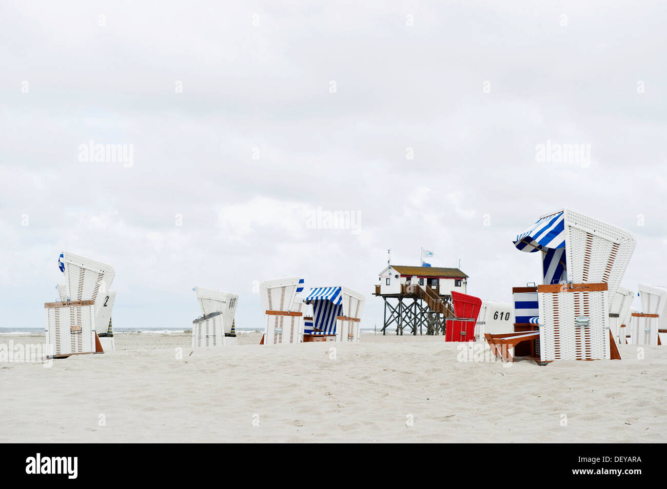 Aufbauend auf Stelzen und überdachten Wicker Liegestühle am Strand von St. Peter-Ording, Nordfriesland, Schleswig-Holstein Stockfoto