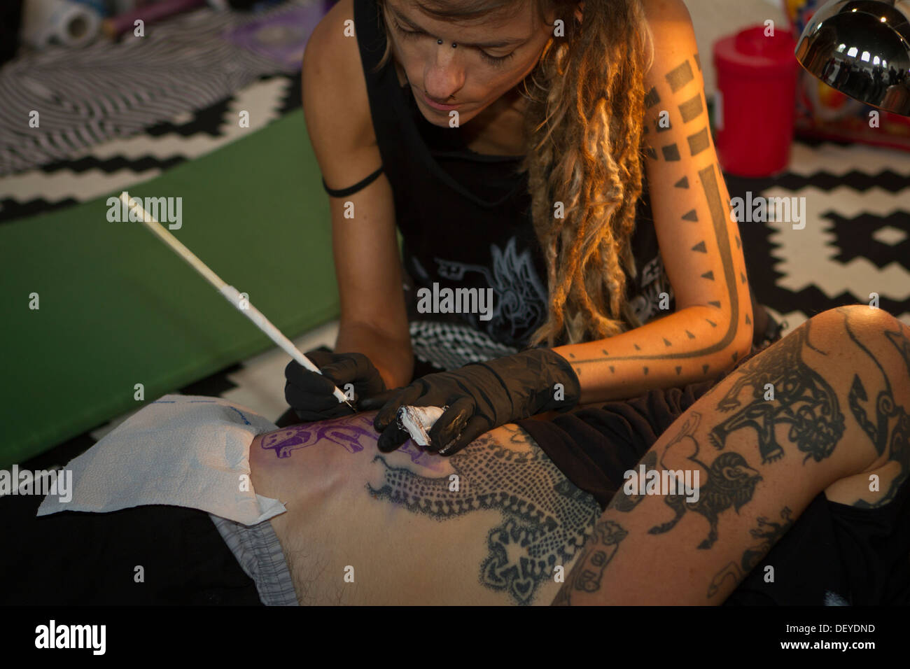 Ein Tätowierer erstellen neues Tattoo mit traditionellen Hand klopfen während der Tattoo Convention 2013 in Kattowitz, Polen. Stockfoto