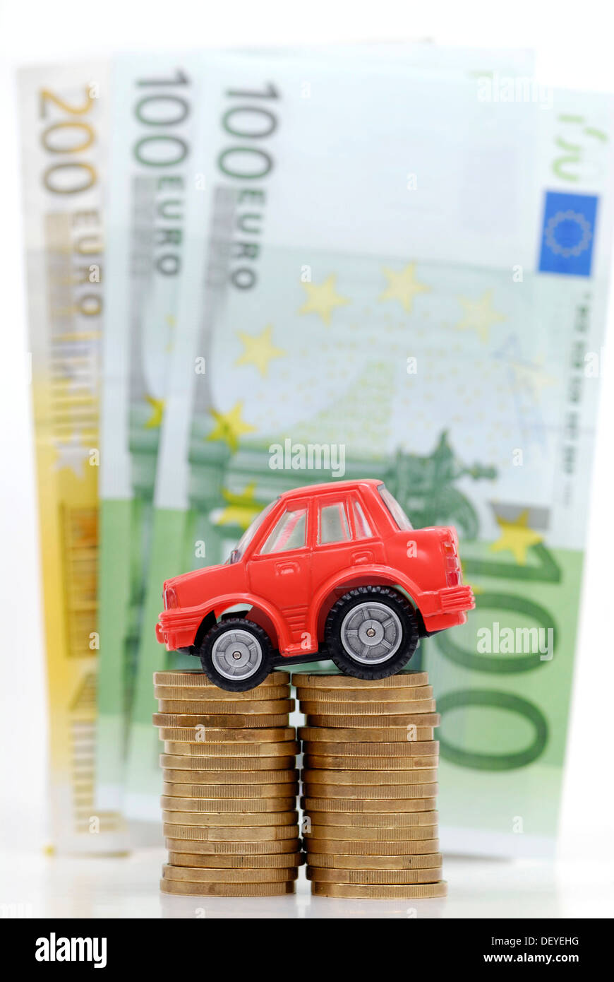 Miniatur-Auto auf einen Stapel von Münzen, Maut symbolisches Bild für Auto Stockfoto
