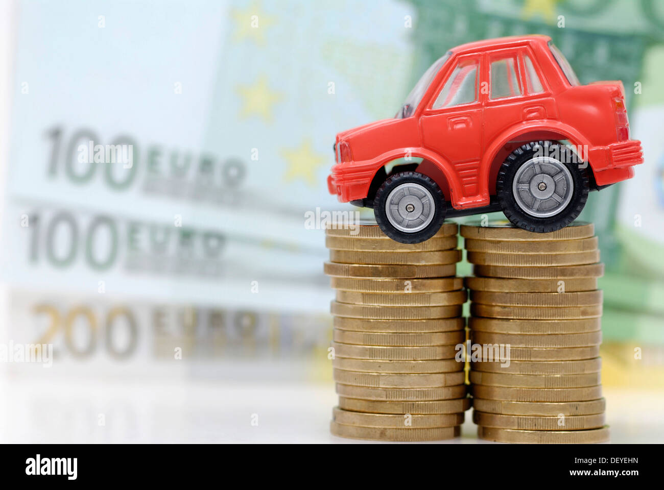 Miniatur-Auto auf einen Stapel von Münzen, Maut symbolisches Bild für Auto Stockfoto