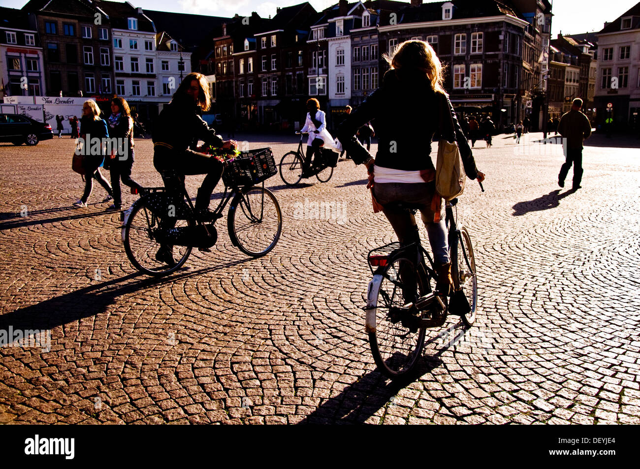 Schatten und Silhouetten auf Markt Maastricht Niederlande drei Frauen Radfahrer Stockfoto