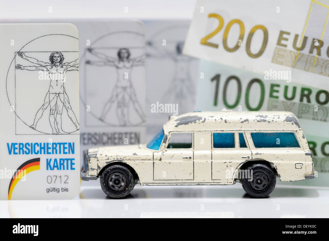 Krankenversicherungskarten und Miniatur-Ambulanz, symbolisches Bild für die finanziellen Schwierigkeiten der Krankenkassen Stockfoto