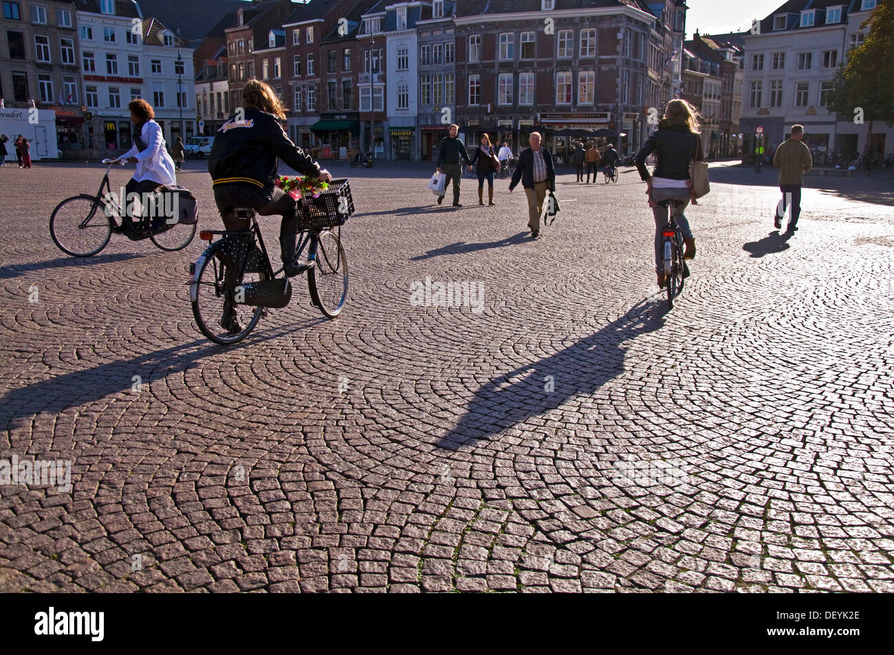 Schatten und Silhouetten auf Markt Maastricht Niederlande drei Frauen Radfahrer Stockfoto