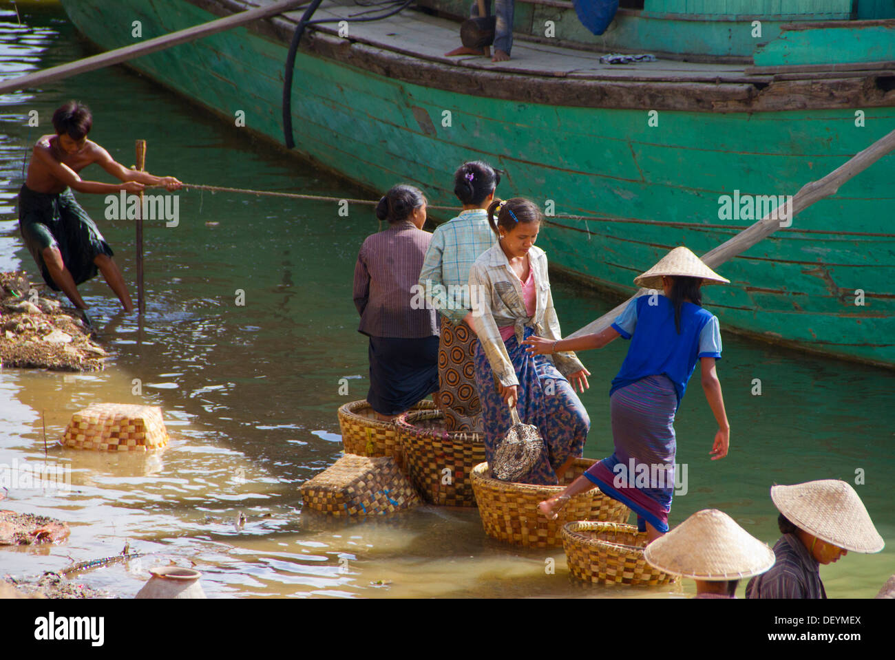 Frauen Stomp und spülen auf dem Ayeyarwady Fluss in Mandalay, Birma zu produzieren. Stockfoto