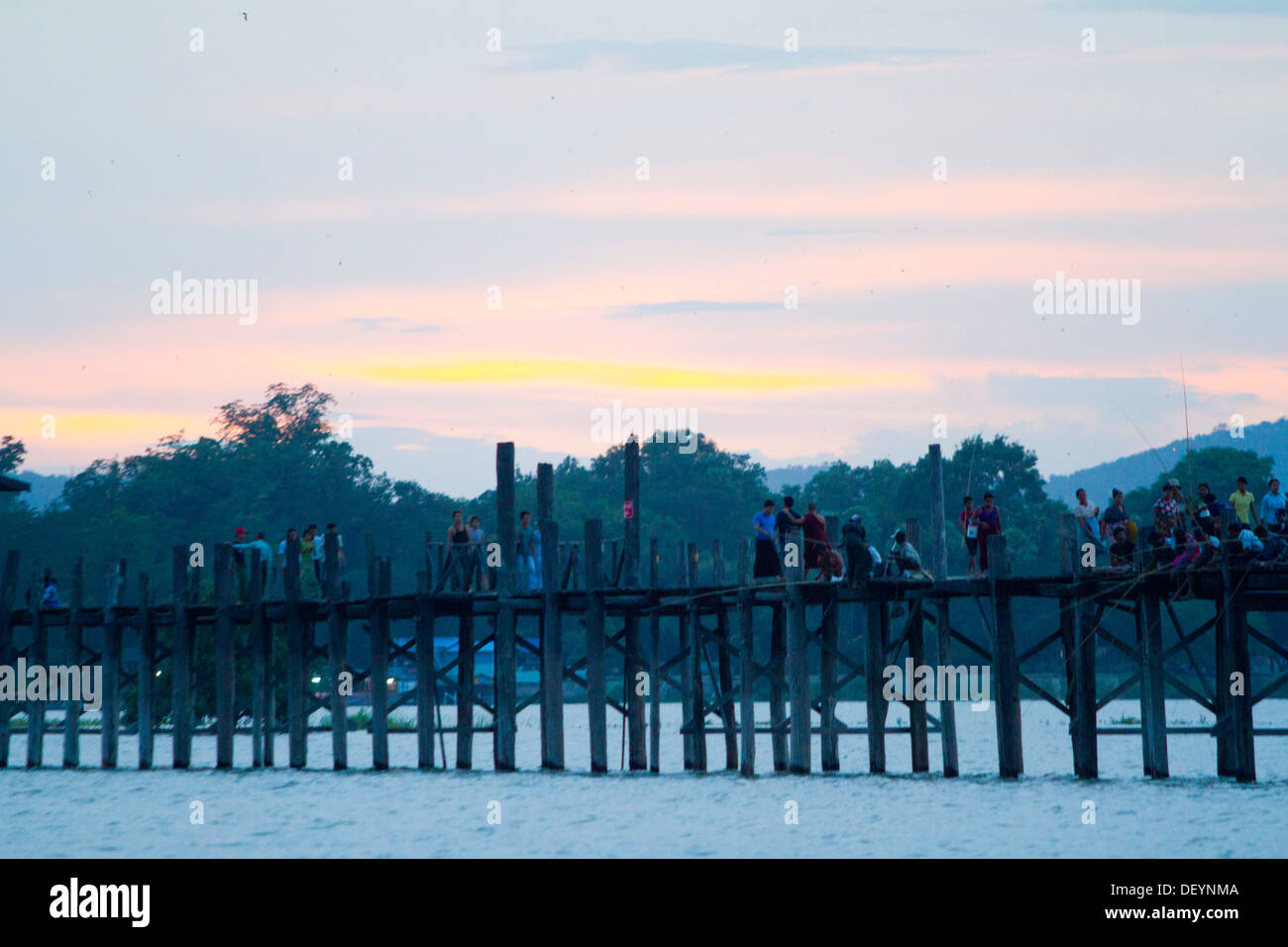 Die Menschen gehen U Bein Brücke bei Sonnenuntergang im Taungthaman See außerhalb Mandalay, Birma. Stockfoto