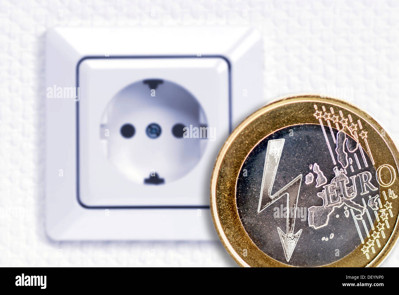 Ein-Euro-Münze mit einem Blitz Blitz-Power-Symbol vor einer Steckdose,  symbolisches Bild für steigende Stromkosten Stockfotografie - Alamy