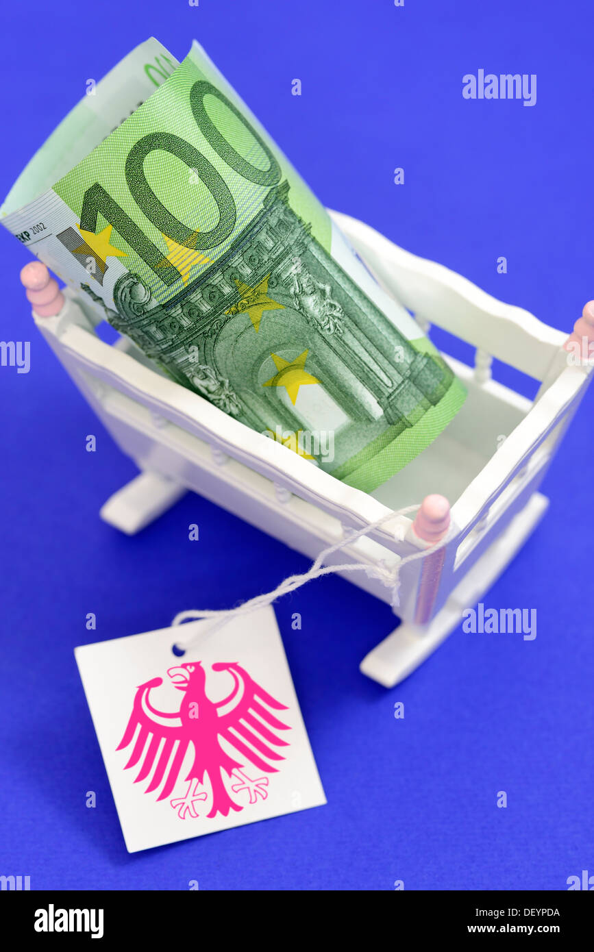 Kind Wiege mit Euro hundert und Label mit Bundesadler, symbolische Foto Pflege Geld, Kinderwiege Mit Hundert-Euro-Schei Stockfoto