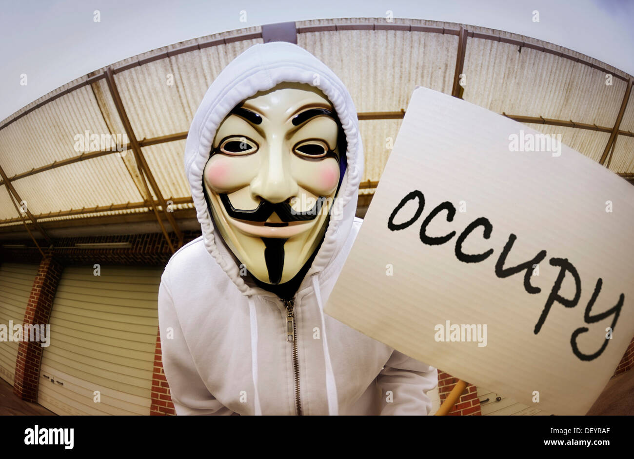 Mann trägt die Guy Fawkes Maske anhand der Occupy-Bewegung mit einem  Protest-Schild, protestieren gegen die Macht der Banken Stockfotografie -  Alamy