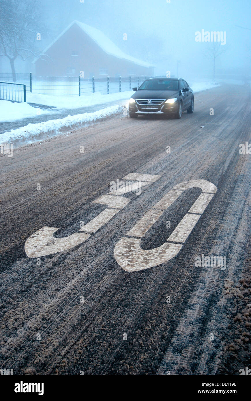 Rutschgefahr in einer beruhigten Bereich, Schneematsch auf einer winterlichen Straße mit Nebel, Borken, Gemen Bezirk, Münsterland Stockfoto