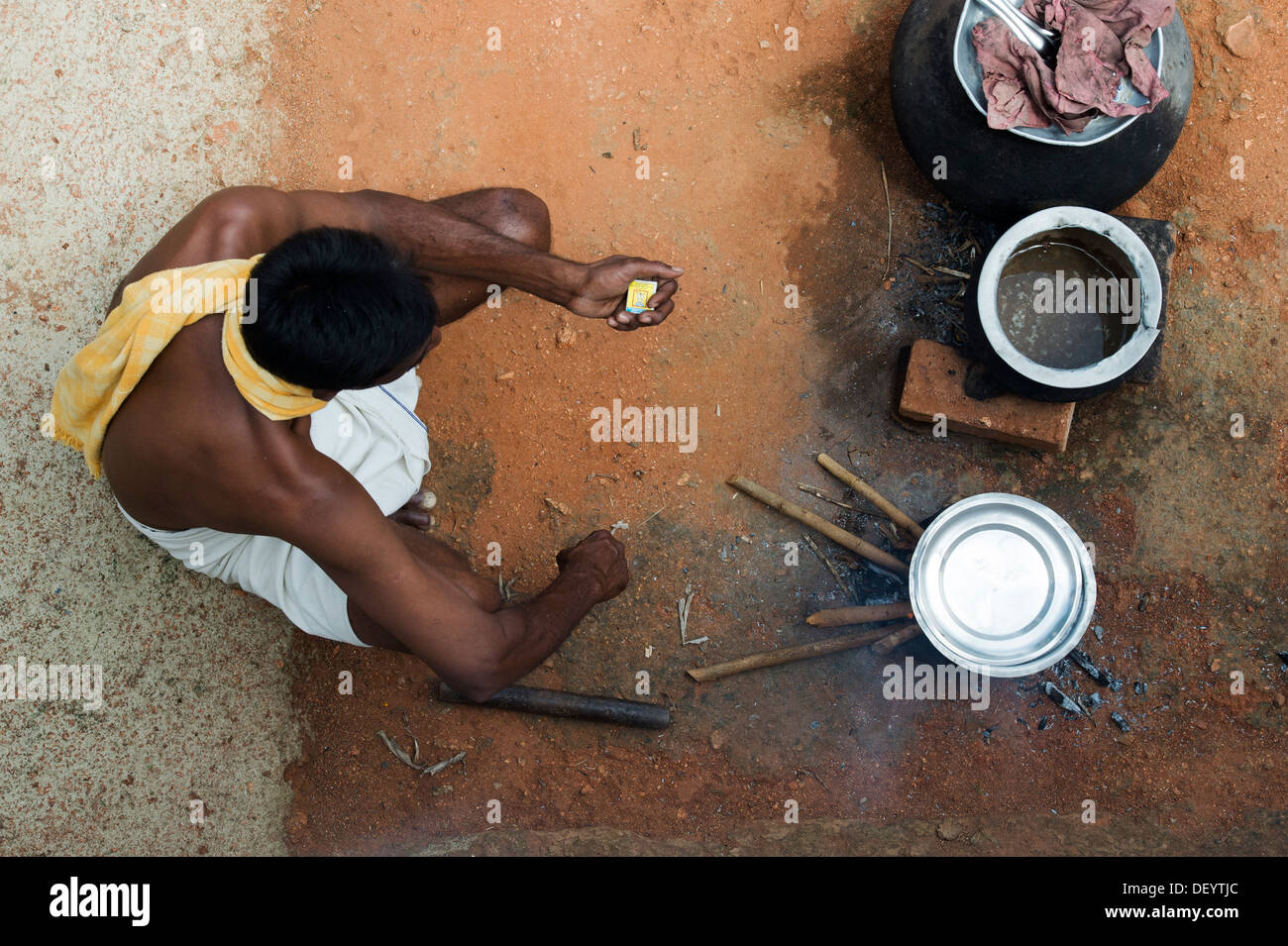 Indische Bauerndorf Mann Kochen Reis auf eine offene Stickfire von oben. Andhra Pradesh, Indien Stockfoto