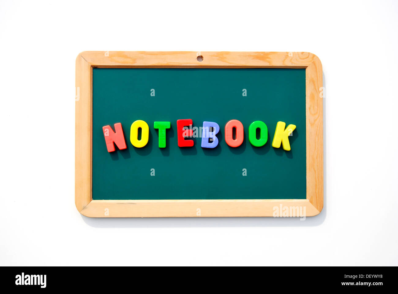 Notebook, Schriftzüge, bunte magnetische Buchstaben auf einem schwarzen Brett Stockfoto