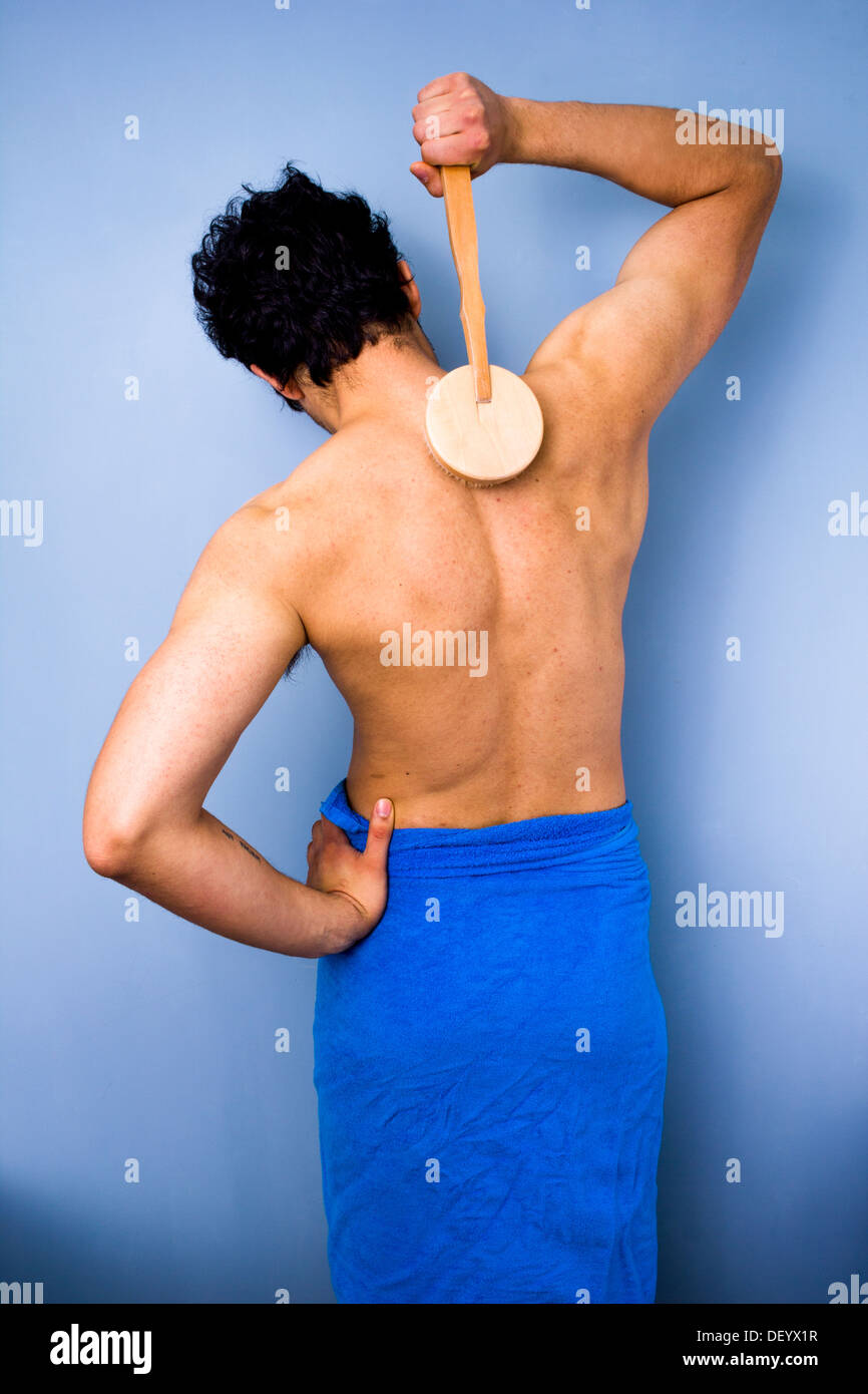Heckansicht des multiethnischen Jüngling seinen Rücken mit einer Dusche  Bürste schrubben Stockfotografie - Alamy
